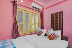 a bedroom with a bed with a window and some pillows at Hotel Sai Guest House, Jadavpur kolkata in Kolkata