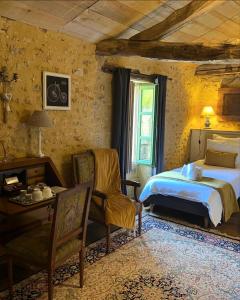 Villa Marguerite Chambres et Table d Hotes de charme في Cadouin: غرفة نوم بسرير وكرسي وطاولة