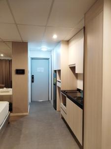 een keuken met witte kasten en een deur naar een slaapkamer bij Smart Condominium Official in Cagayan de Oro