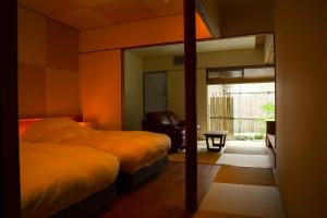 1 dormitorio con 2 camas y espejo en Maki No Oto Kanazawa en Kanazawa
