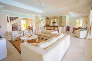 una sala de estar con sofás blancos y una mesa. en Eden Island Luxury Ocean Front Villa with Pool en Victoria
