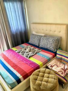 a bed with a colorful comforter sitting next to a window at JT Tagaytay Suites in Tagaytay