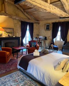a bedroom with a large bed and a living room at Villa Marguerite Chambres et Table d Hotes de charme in Cadouin