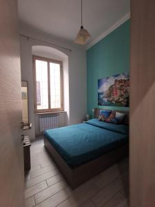 una camera con un letto blu e un dipinto sul muro di Speziamare a La Spezia