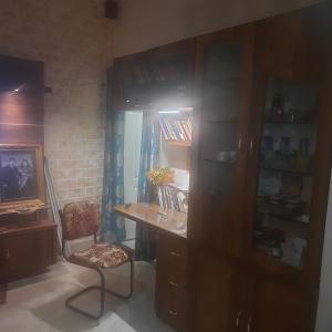 um quarto com uma secretária, uma cadeira e uma estante de livros em Premanand's House em Raipur