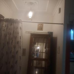 um quarto com uma porta com uma cortina e uma luz em Premanand's House em Raipur