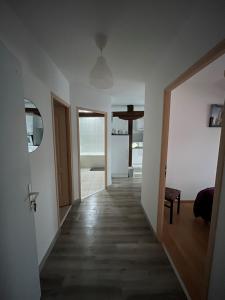 un corridoio che conduce a un soggiorno con pareti bianche di Appart COSY proche METZ 