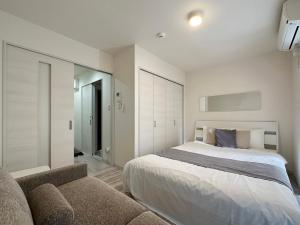 1 dormitorio con 1 cama y 1 sofá en bHOTEL Yutori - Homey w 1BR in Onomichi for 3 Ppl, en Onomichi