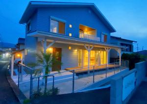 a blue house with a deck at night at 唐津 海辺の家 in Fuchinoue