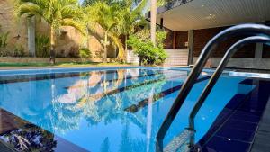 een zwembad met palmbomen en een gebouw bij Villa De Lanerolle in Attidiya