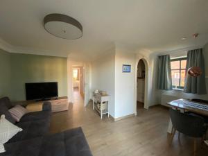 a living room with a couch and a flat screen tv at Ferienwohnung Groß Zicker in Groß Zicker