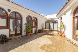a courtyard of a house with a table and plants at Casa Laura in Almuñécar