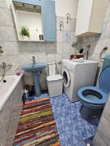 a bathroom with a toilet sink and a washing machine at Apartman Nira in Zenica