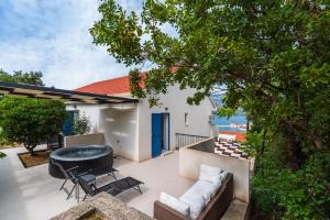 a patio with a couch and a table and chairs at Infinity Dalmatia Apartments in Vinjerac