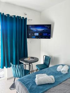 a bedroom with a bed and a table and a tv at STR Apartment in Tivat