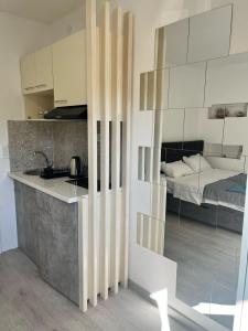 - une cuisine avec évier et un lit dans une chambre dans l'établissement STR Apartment, à Tivat