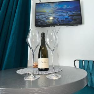 a bottle of wine and two wine glasses on a table at STR Apartment in Tivat