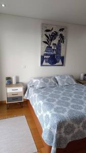 um quarto com uma cama e uma mesa de cabeceira em Casa Monte Ponta do Sol SeaViews em Ponta do Sol