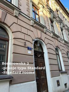 un bâtiment avec une porte en bois sur son côté dans l'établissement Apartamenty Bonerowska 5, à Cracovie
