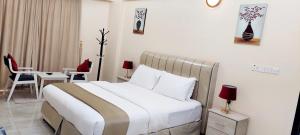 a bedroom with a bed and a table and chairs at Pearl Hotel Apartment - اللؤلؤ للشقق الفندقية in Al Buraymī