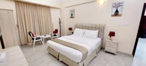 une chambre d'hôtel avec un lit, une table et des chaises dans l'établissement Pearl Hotel Apartment - اللؤلؤ للشقق الفندقية, à Al Buraymī