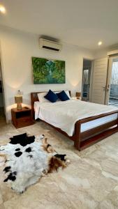 una camera da letto con un letto e un tappeto di mucca sul pavimento di Private suite in a kids friendly big shared villa in Canggu a Canggu