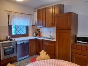 a kitchen with wooden cabinets and a toy dog in the kitchen at Villa Bianca Bormio garden and parking in Premadio