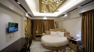 ダッカにあるXpressmall Hotel near Dhaka Airportのベッドとテレビが備わるホテルルームです。