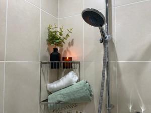 a shower shelf in a bathroom with towels at Oadby Town Mid-Century Bungalow in Oadby
