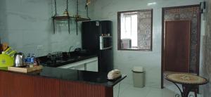 uma cozinha com uma geladeira preta e um balcão em No coração de Boa Viagem em Recife mais 19 fotografias