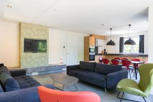 Una sala de estar con sofás y una mesa y sillas. en Duinbraam, en Den Burg