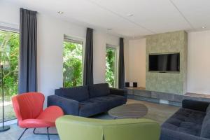 Una sala de estar con dos sofás y un televisor. en Duinbraam, en Den Burg