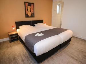 Un dormitorio con una cama grande con un perro. en Duinbraam, en Den Burg