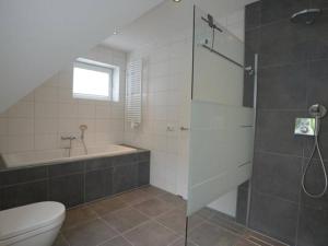 Un baño con ducha, inodoro y bañera. en Duinbraam, en Den Burg 10 fotos más