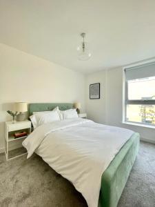 a bedroom with a large bed and a window at Central Shoreditch Flat By Box Park & Spitalfields Market in London