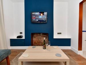 ein Wohnzimmer mit einem Tisch und einem TV an der Wand in der Unterkunft Pass the Keys Cosy 2 bed home in Pontcanna in Cardiff