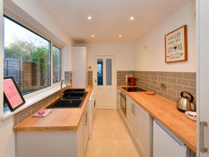 eine große Küche mit einem Waschbecken und einem Fenster in der Unterkunft Pass the Keys Cosy 2 bed home in Pontcanna in Cardiff