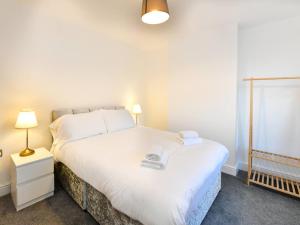 ein Schlafzimmer mit einem großen weißen Bett und einer Lampe in der Unterkunft Pass the Keys Cosy 2 bed home in Pontcanna in Cardiff