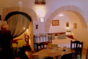 a living room with a table and a bed in a room at Miratrulli Apartment & Trullo dell'Aia in Alberobello