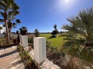 a row of white posts in a yard with palm trees w obiekcie Atico Playa Granada Marina Golf w mieście Motril