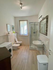 uma casa de banho com 2 lavatórios, um chuveiro e 2 WC em Ledrobenessere em Pieve Di Ledro
