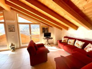 a living room with a red couch and a large window at Ledrobenessere in Pieve Di Ledro