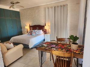 a bedroom with a bed and a table and a couch at Stirling House in Paarl