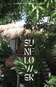 Sunflower Guesthouse and Animal Rescue - Koh Lipe في كو ليبي: لافته مكتوب عليها لذلك أنا أمام كوخ من القش