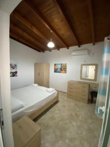 um quarto com uma cama e uma cómoda em Sun n' Blue Villas em Sarandë