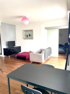 a living room with a table and a couch at Charmant appartement en bord de Cher in Saint-Avertin