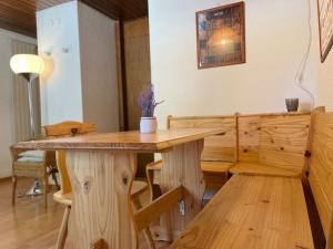 - une table et des chaises en bois dans l'établissement Fuite en Montagne, à Crans-Montana