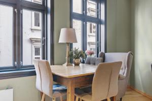 a dining room with a table and chairs and windows at Peaceful Urban Residence in Bergen