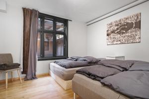 1 Schlafzimmer mit 2 Betten und einem Fenster in der Unterkunft Peaceful Urban Residence in Bergen