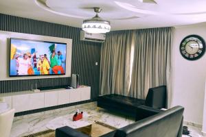 uma sala de estar com uma televisão na parede em aPogee Home em Abuja